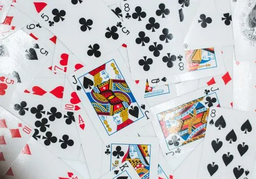 A pile of cards lying shuffled on a flat surface, presumably in anticipation of setting up and starting a game of spades