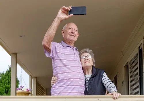 An elderly couple practicing mobile photography as a hobby