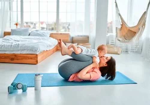 A stay at home mom doing home yoga with her baby