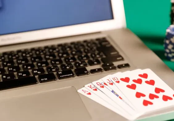Some playing cards laid on top of a laptop