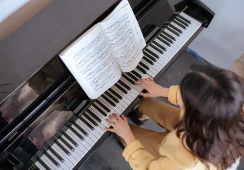 Alt img text: A woman playing a piano 