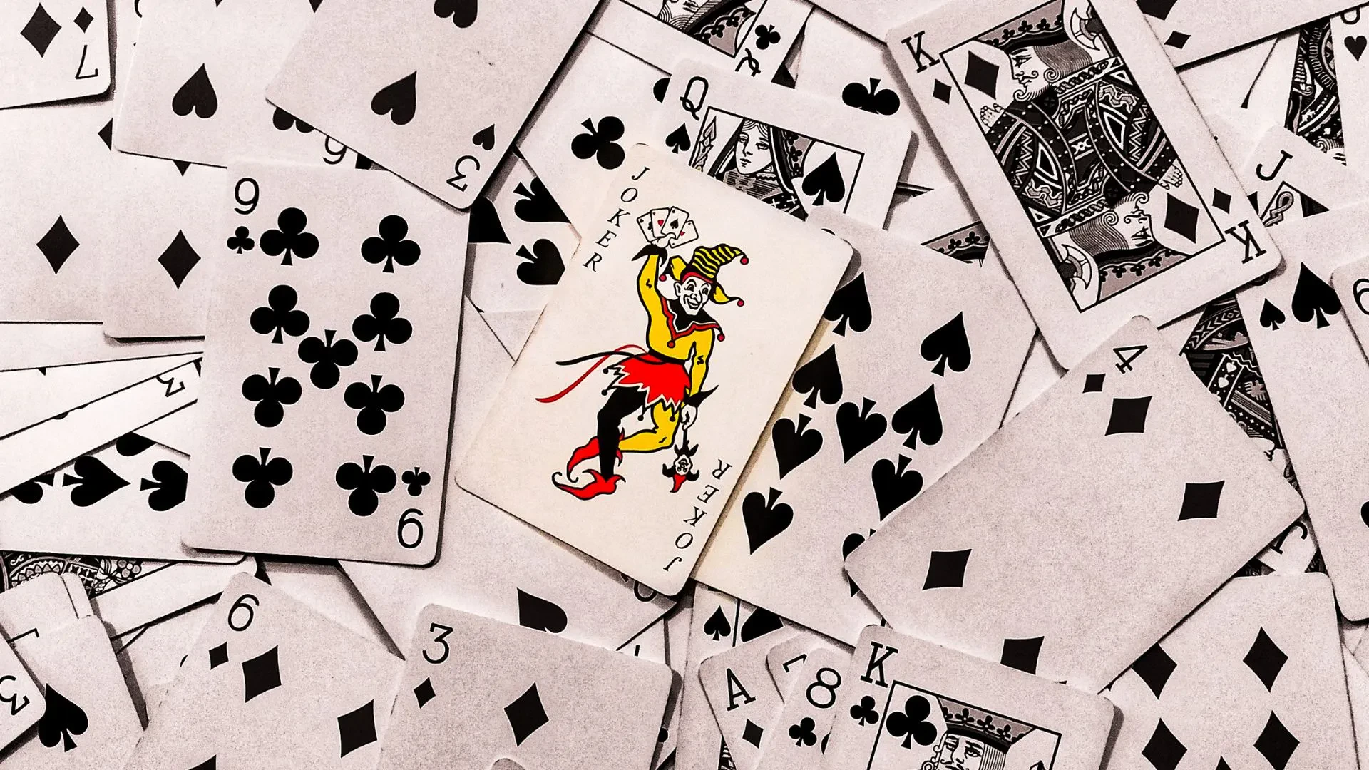 The joker in the center of black playing cards