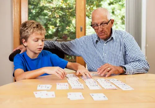 A grandfather and a child playing solitaire together